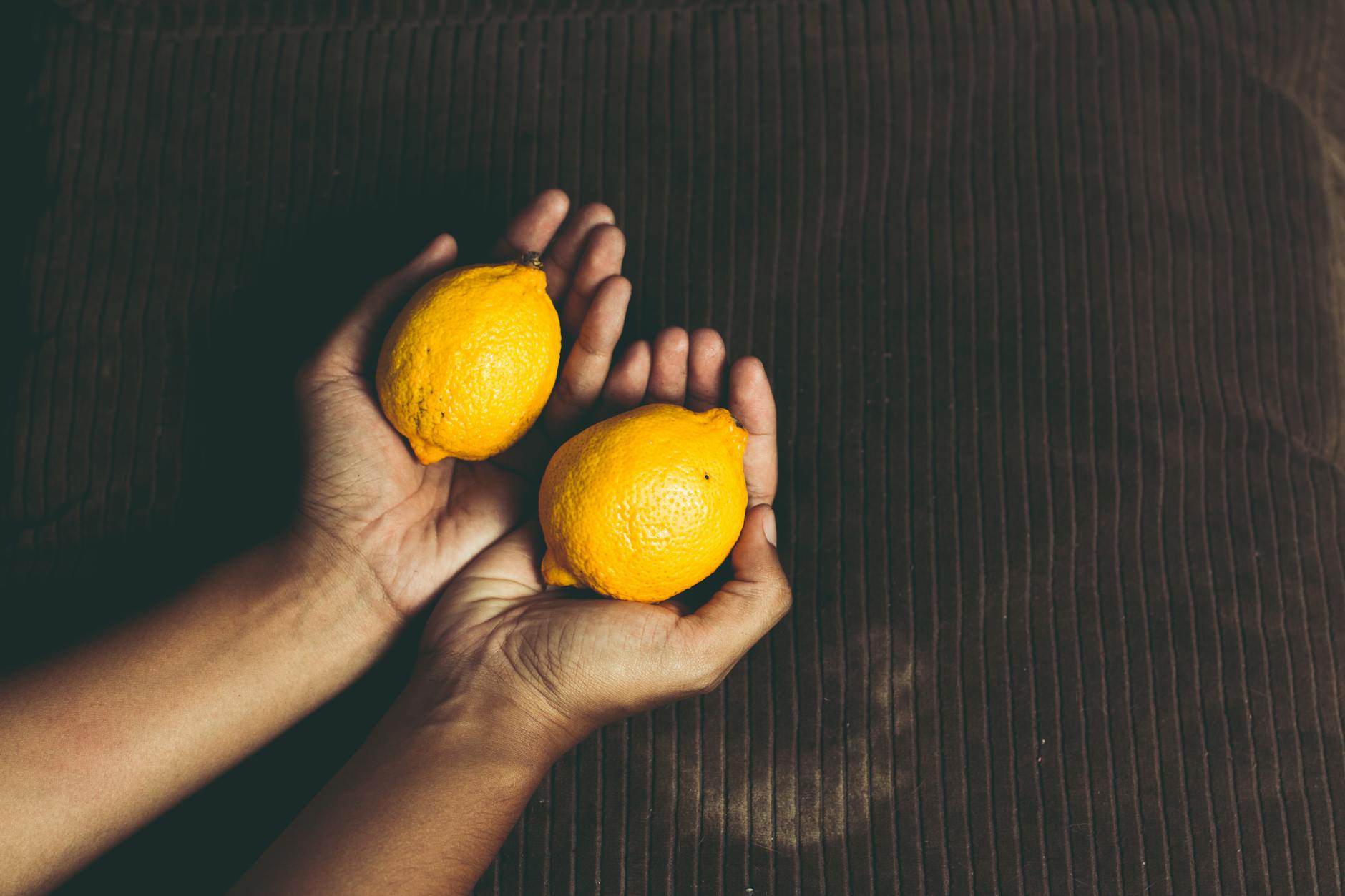 Two fresh lemons held in cupped hands, symbolizing the care and attention your body deserves
