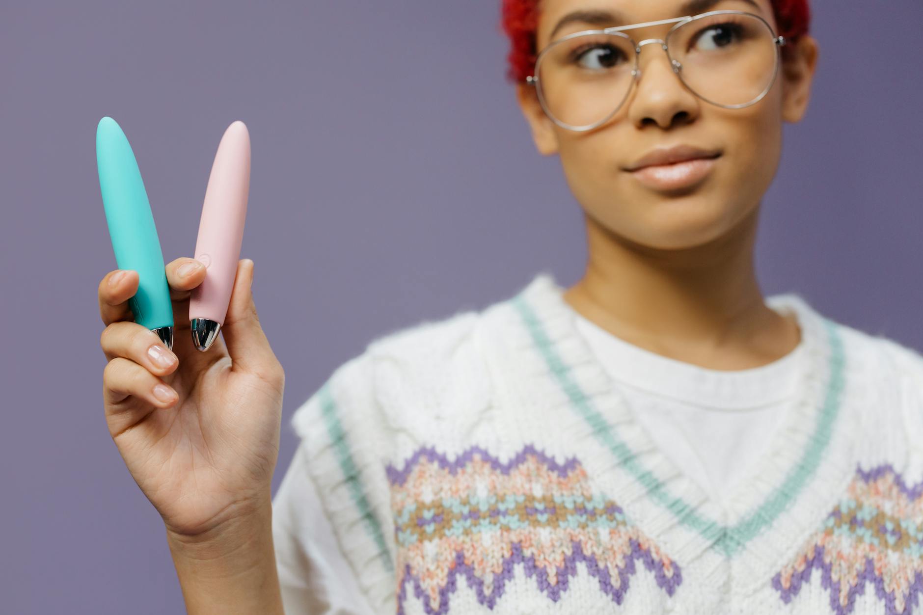 Woman holding two vibrators thoughtfully, representing the journey back to desire