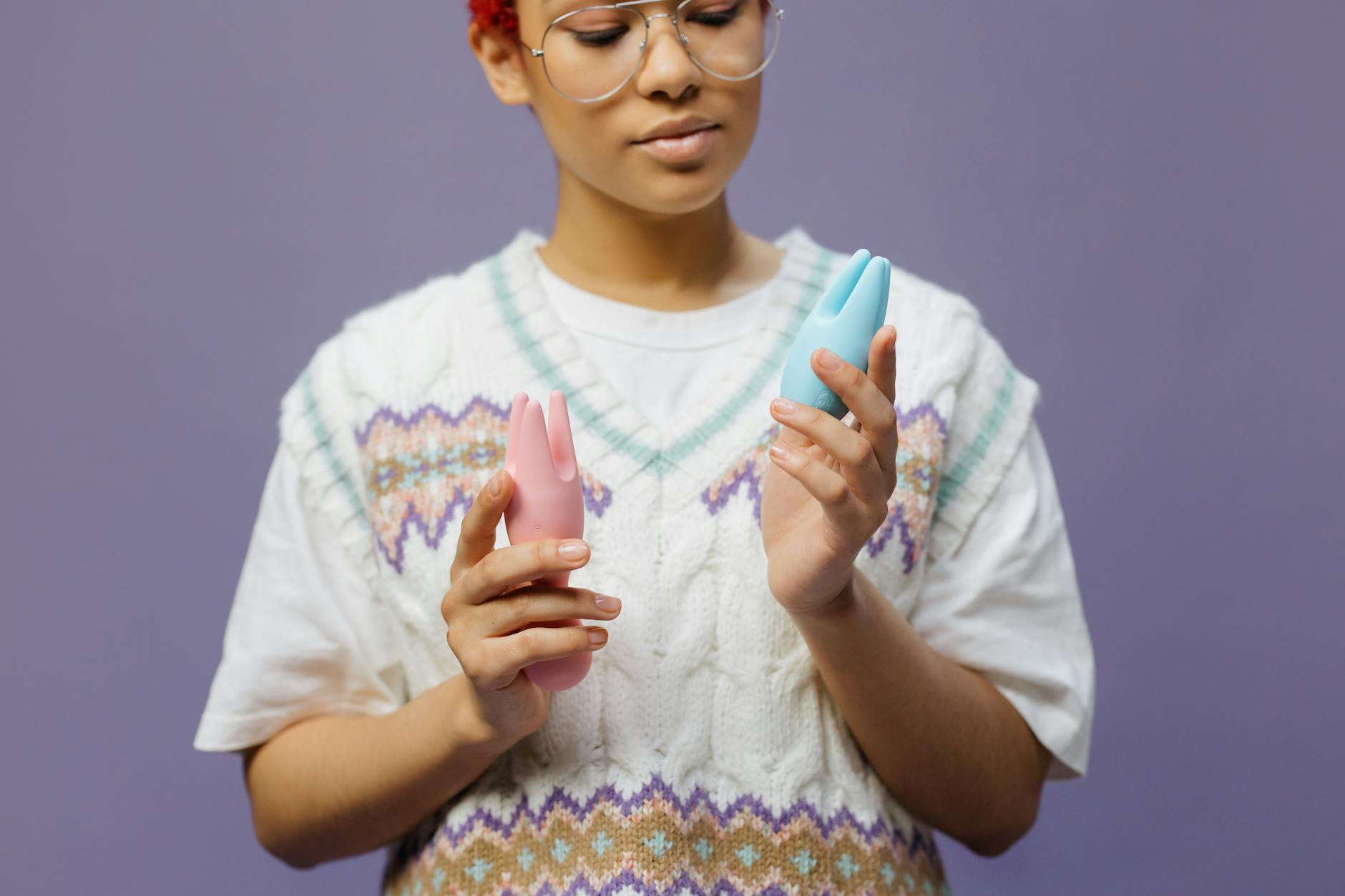 Woman holding colorful silicone vibrators in a contemplative moment, reflecting on reconnecting with pleasure